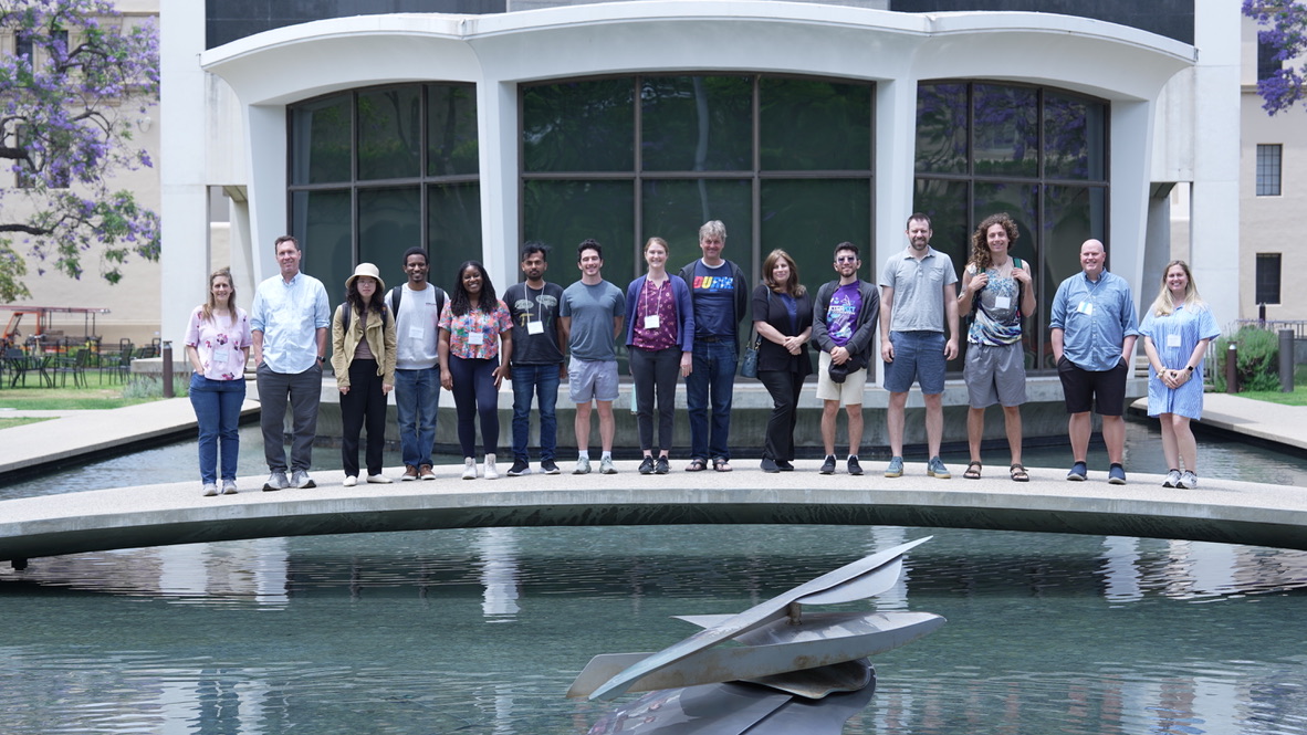 Workshop participants posing together on a bridge over a reflecting pool at Caltech.